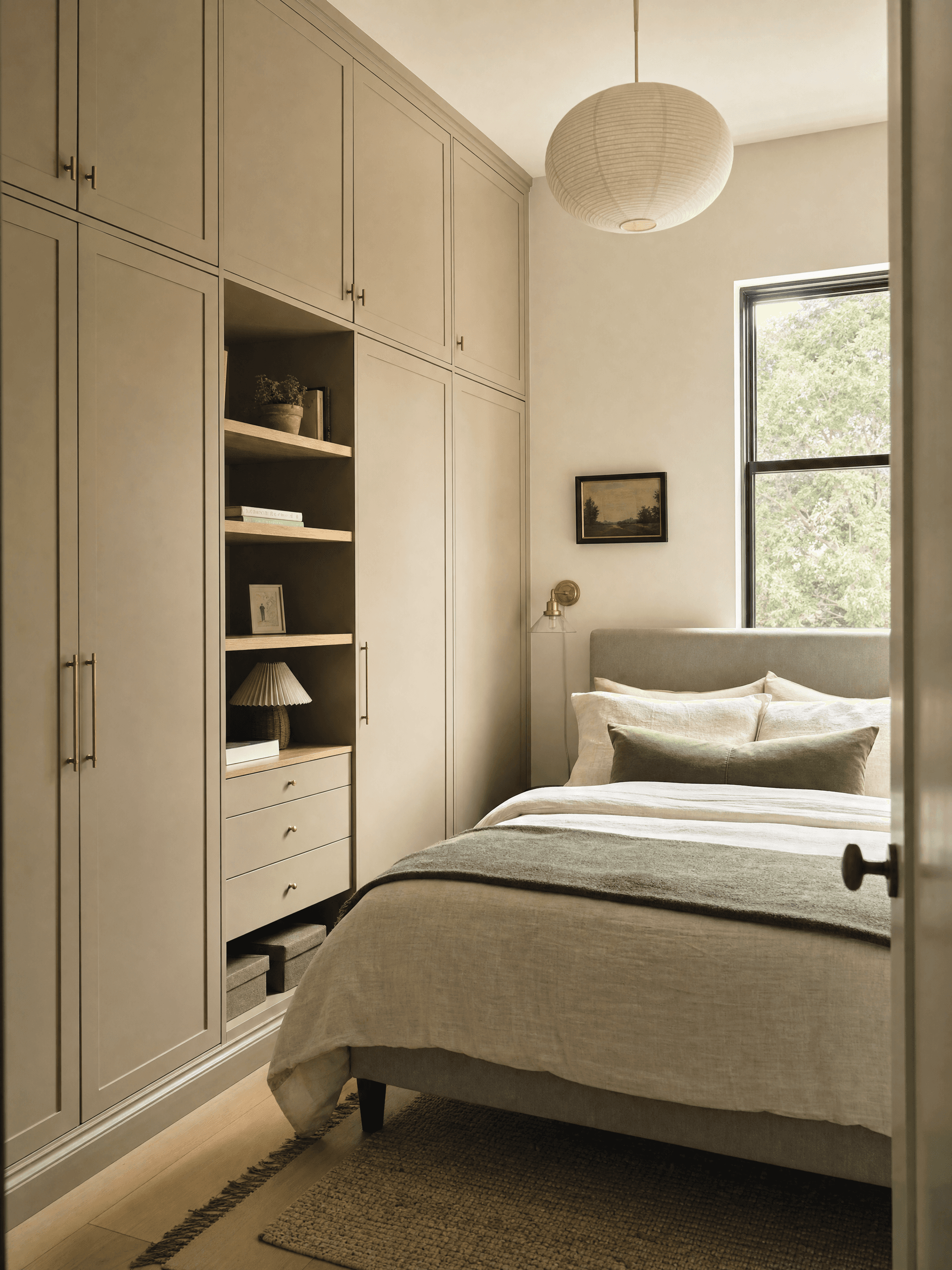 Small stylish bedroom with tall built-in-looking storage reaching nearly to ceiling
